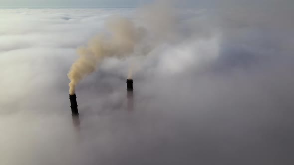 Coal Power Plant High Pipes with Black Smoke Moving Upwards Over Clouds Polluting Atmosphere alt