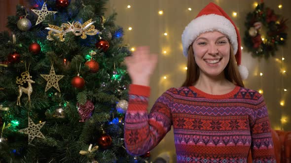 Young Pretty Woman in Santas Hat Having Video Chat at Home Near Christmas Tree alt