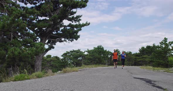 Young Couple in Medical Face Masks Running on the Road During a Pandemic alt