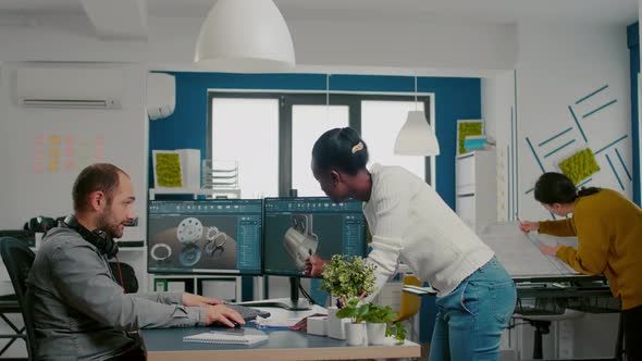 Multiethnic Team Sharing Ideas About Industrial Project Using Two Monitors alt