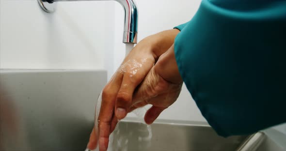 Male surgeon washing his hands alt
