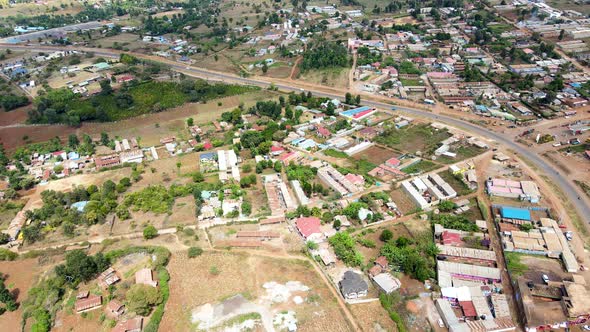 Aerial flyover poor Kibera Slum and modern skyline of Nairobi in background during sunny day. alt