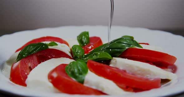 Pouring Olive Oil Over Italian Caprese Salad 02b