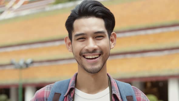 Smiling portrait of handsome young Asian man tourists traveling.