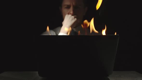 Businessman Is Thinking At The Burning Laptop