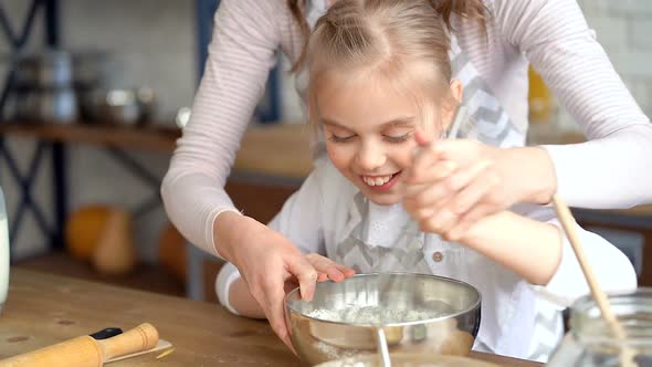 Mother and Daughter Cooking and Kneading Eggs