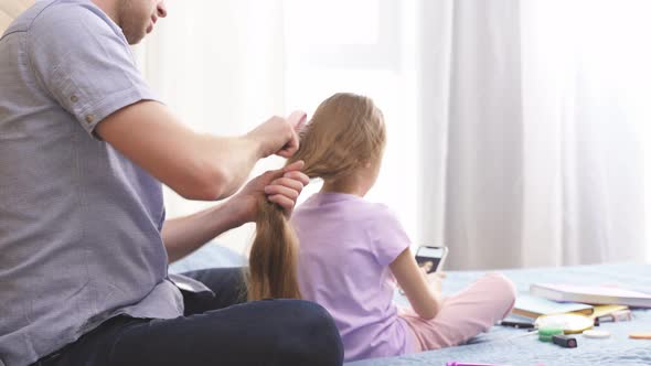 Young Father Brushing and Braiding Cute Little Daughter Hair Enjoy Spending Time Together at Home