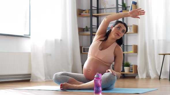 Pregnant Woman Drinking Water After Yoga at Home alt