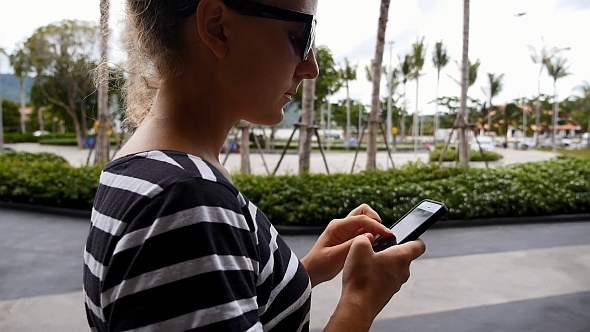 Woman Using Smartphone and Walking alt