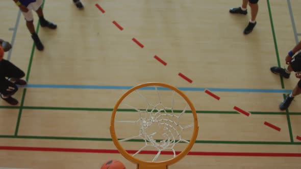 Overhead view of african american male basketball player scoring goal against diverse players alt