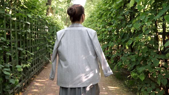 Young Woman Walks Through the Garden and Turns Around Smiling alt