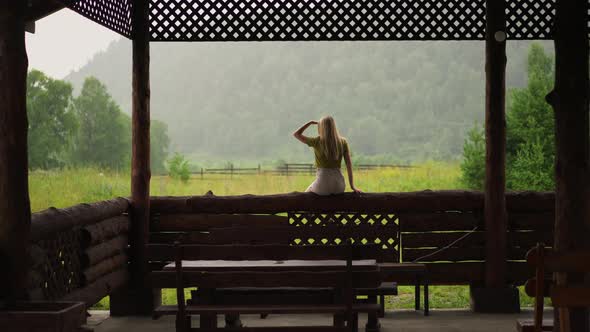 Lady Holds Hand Over Eyes and Looks at Distant Mountains alt