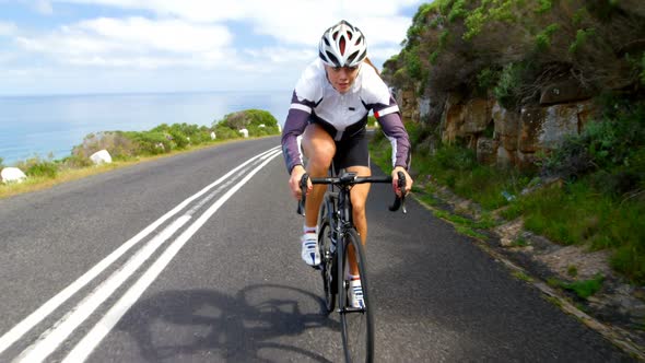 Female cyclist cycling on a countryside road alt