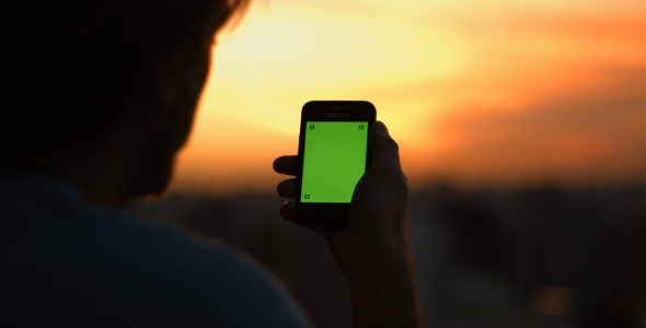 Man Talking On His Cellphone With Green Screen alt