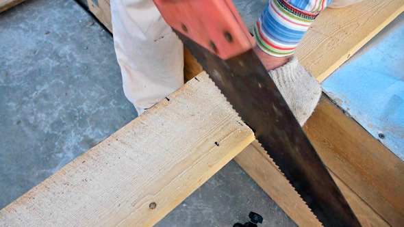 Sawing The Plank With A Hand Saw