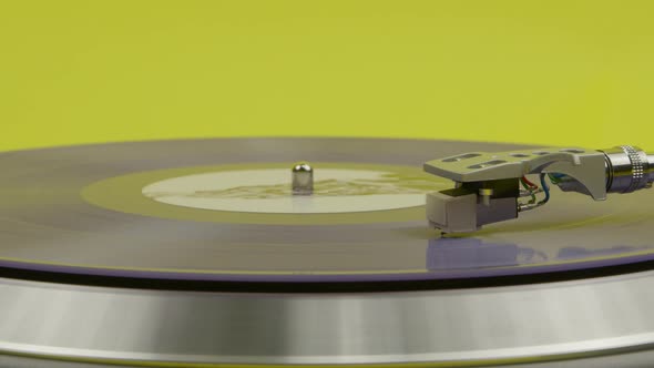 Blue Vinyl Record Spinning on Turntable Isolated on Yellow