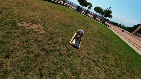 Girl in White Dress Doing Stretching Exercises on the Grass at Sunny Day alt