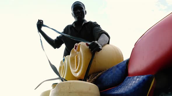African Man Carrying Lake Water alt