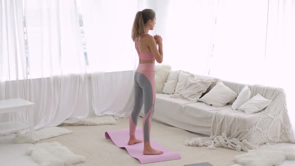 Woman Is Doing Squats Exercise for Glutes Muscles Training at Home, Back View.