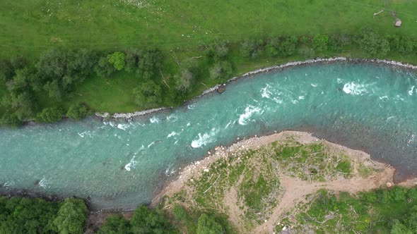 Aerial View of Natural Winding River in Green grass field