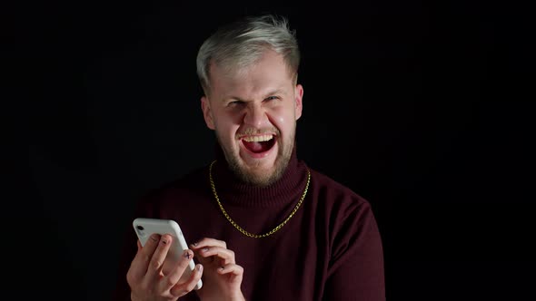 Shocked Happy Smiling Winning of Man While Browsing on Smartphone Feeling Happiness Fun Enjoyment alt