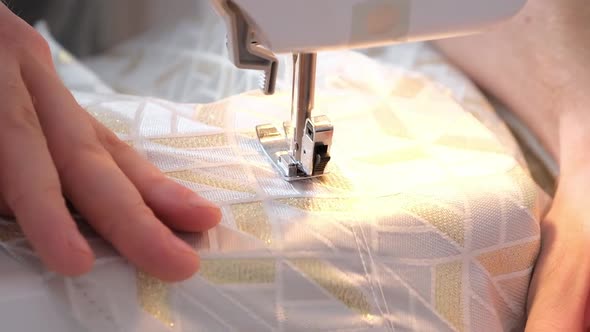 A Man Sews Clothes on Sewing Machine