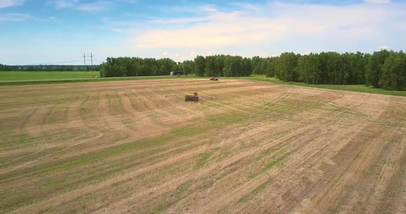 Motorized Sprinkler Moves on Field Along Road with Cars alt