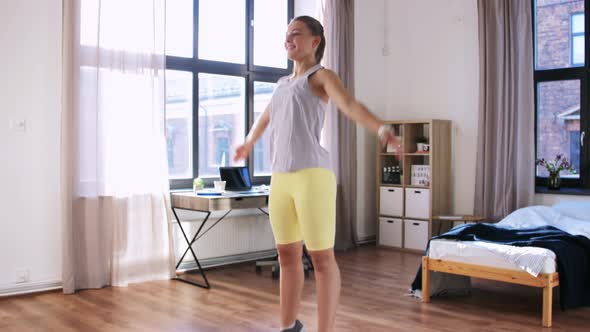 Happy Teenage Girl Exercising and Jumping at Home
