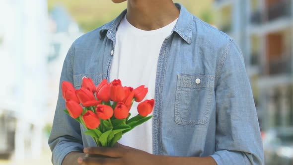 Worried Boy Holding Flowers, Looking Out For Girlfriend alt