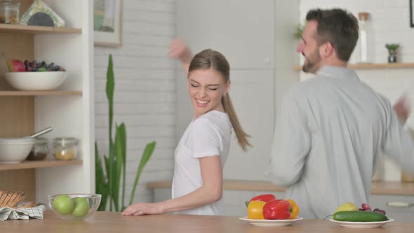 Woman and Man Dancing in Kitchen alt