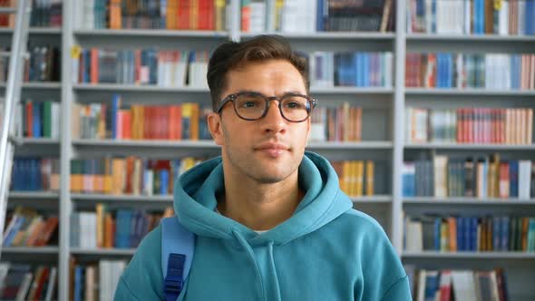Young Student Millennial with Glasses Looking at the Camera and Smiling While Standing in a Public