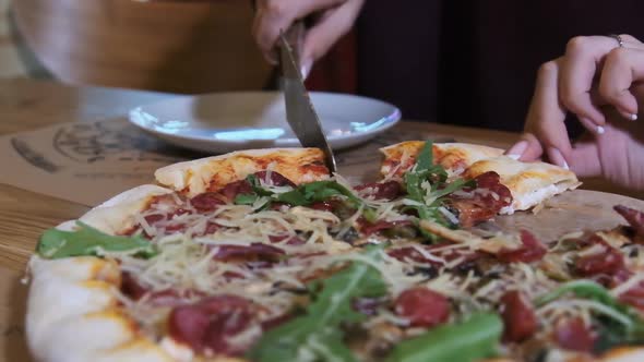 Woman Hands Taking a Slice of the Pizza From a Wooden Plate in the Restaurant. Slow Motion alt
