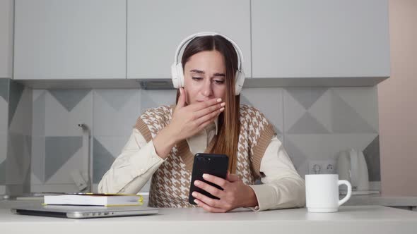Very Upset Young Woman Reading a Message on your Mobile Phone Crying alt