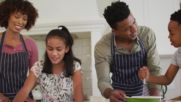 African american family baking together in the kitchen at home alt
