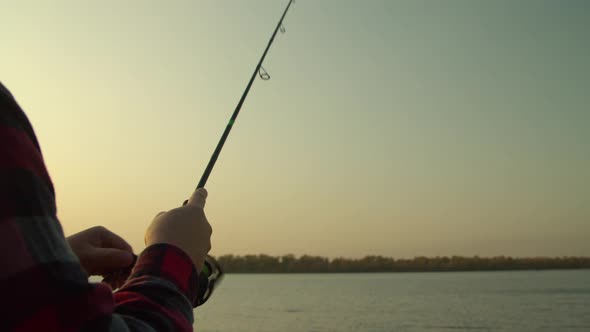 Crop Man Angling at Sunrise in Nature