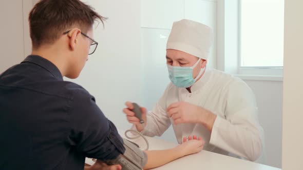 A Doctor in Latex Gloves Using a Pulse Oximeter Measures the Level of Oxygen in the Patient's Blood alt