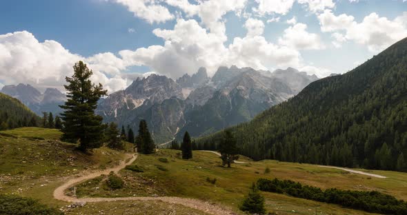Time lapse of alpine mountrain range in 4k. Clouds moving fast with sun rays on alt