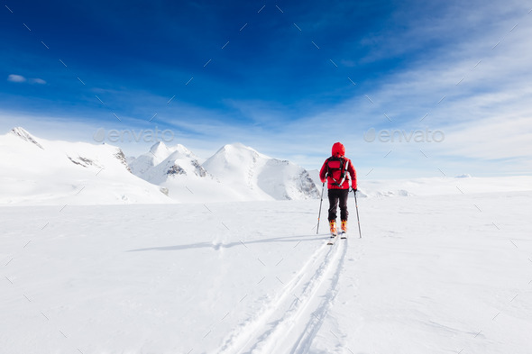 Mountaineer walking on a glacier during a high-altitude winter expedition in the european Alps. - Stock Photo - Images
