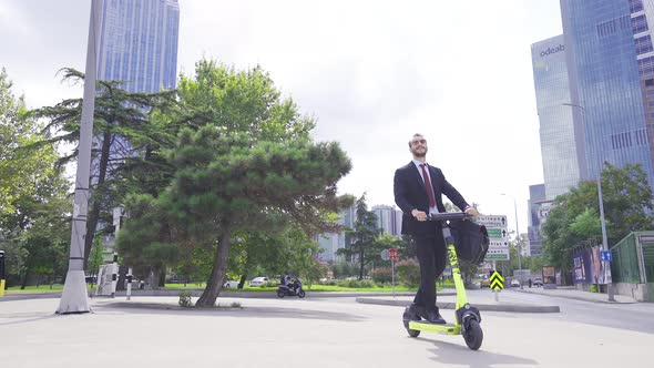 Businessman driving electric scooter. alt