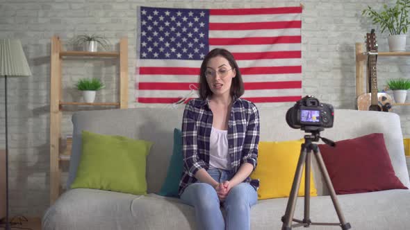 Portrait Oung Woman Blogger in Shirt on American Flag Background Recording Video alt