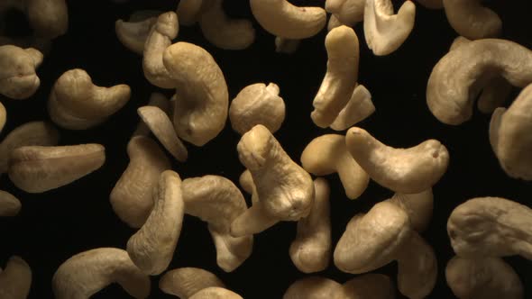 Cashew Nuts Flying In The Air In A Free Fall In Slow Motion On Black Background 4K alt