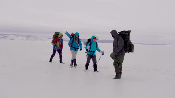 Two Men and Women with Trekking Equipment and Ski Poles. alt