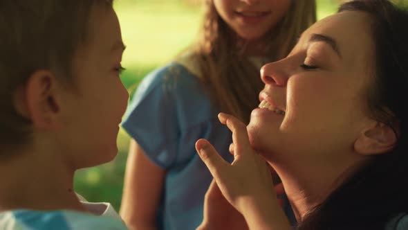 Happy Mother Caressing Son on Nature Close Up alt