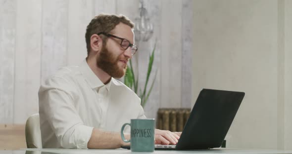 Happy Businessman Dancing Cheerfully While Working at Laptop in Home Office