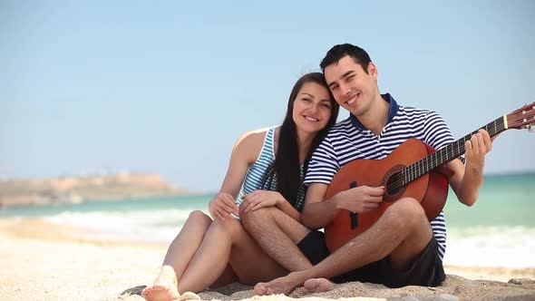 happy young couple embracing on the sand on the beach