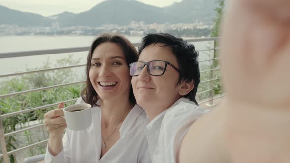 POV Two Women Friends on Vacation on Terrace Take Selfie on Phone Camera Rbbro alt