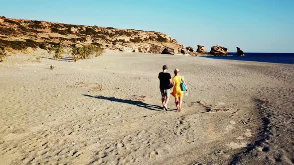 Aerial Drone Footage of a Couple Walking Along a Lonely Beach