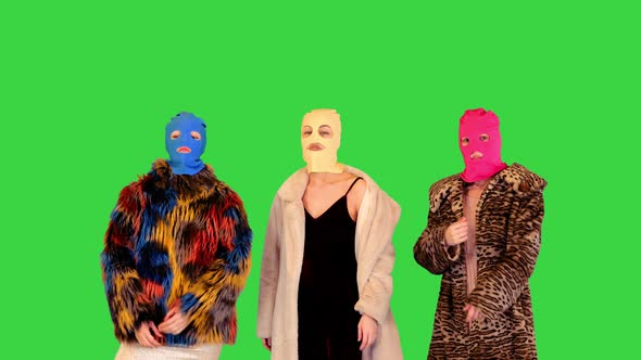 A Group of Girls in Colored Balaclavas Pose in Fashionable Manner on a Green Screen Chroma Key