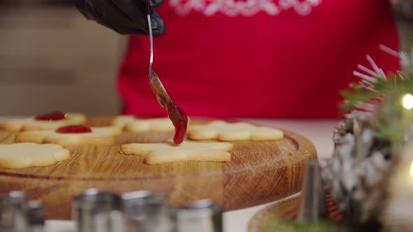 Close Up View of a Woman Hand Making a Gingerbread Cookie Using a Spoon Puts the Jam on the Cookies alt