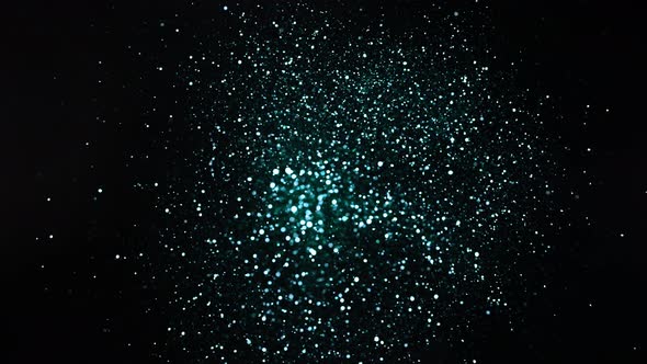 Green and Silver Glitter Explosion in Super Slow Motion on Black Background alt